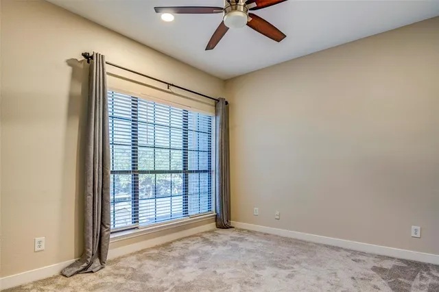 an empty room with a window and a ceiling fan