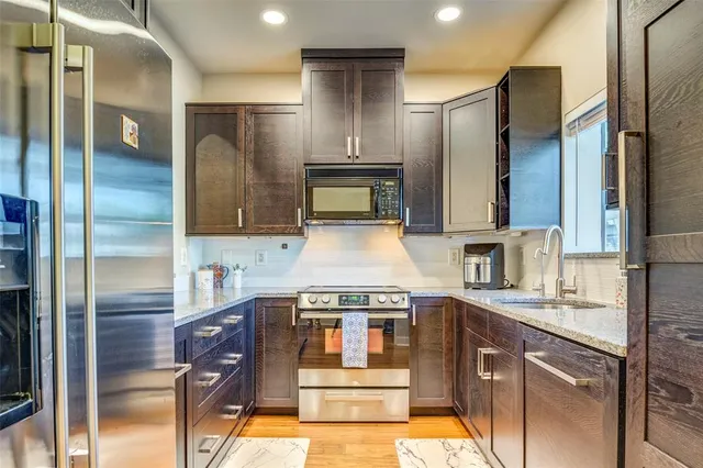 a kitchen with stainless steel appliances granite countertop a sink and a refrigerator