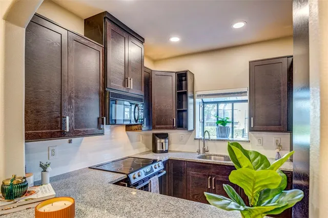 a kitchen with stainless steel appliances granite countertop sink stove and cabinets