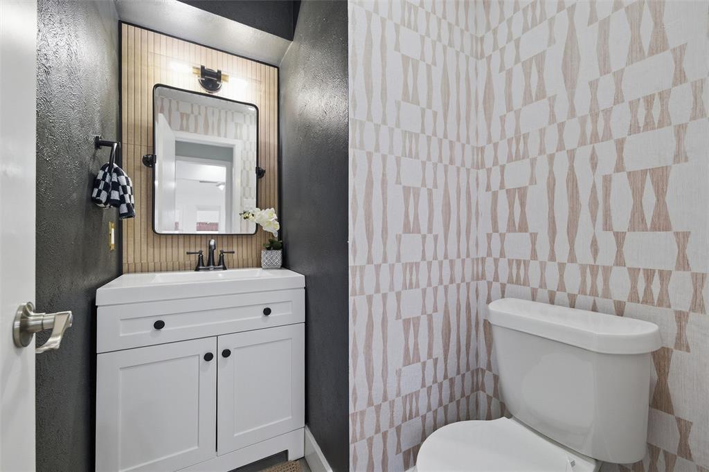 6029 Spring Flower Trail Dallas, TX 75248 - Photo 18 of 37 a bathroom with a toilet a sink and mirror