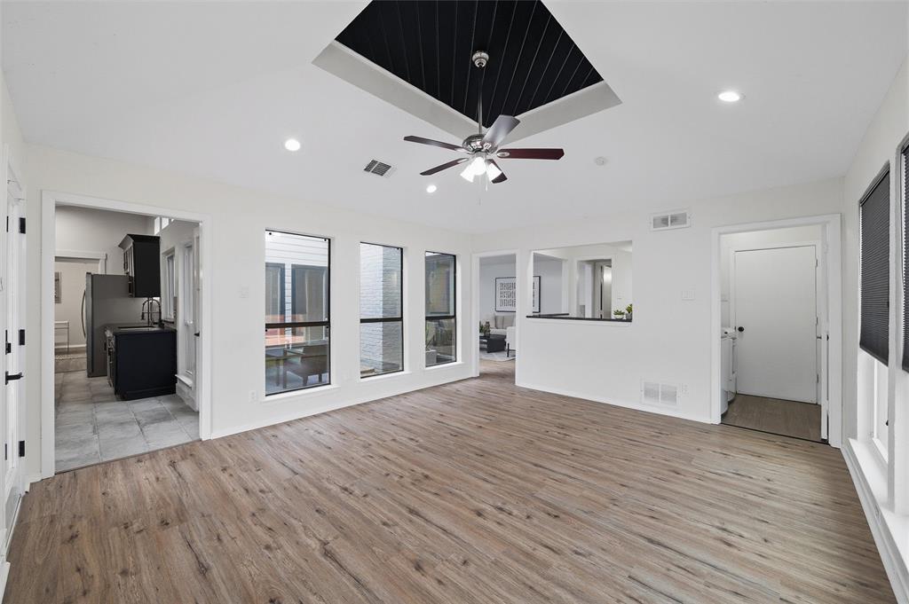 6029 Spring Flower Trail Dallas, TX 75248 - Photo 20 of 37 a view of a big room with wooden floor and a kitchen