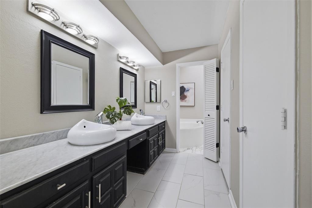 6029 Spring Flower Trail Dallas, TX 75248 - Photo 22 of 37 a spacious bathroom with a granite countertop sink and a mirror
