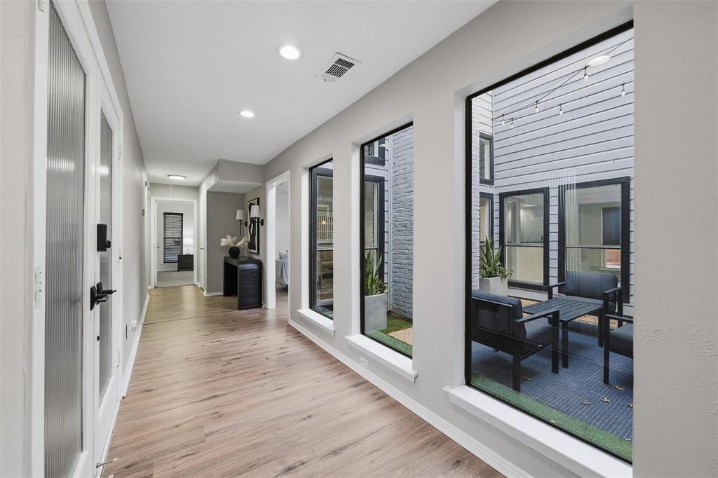 6029 Spring Flower Trail Dallas, TX 75248 - Photo 6 of 37 a view of a hallway with wooden floor and livingroom with furniture
