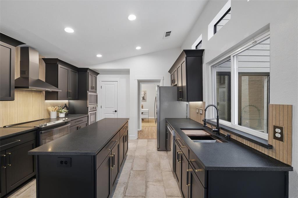6029 Spring Flower Trail Dallas, TX 75248 - Photo 8 of 37 a kitchen with stainless steel appliances a sink stove and refrigerator