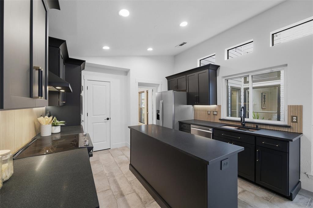 6029 Spring Flower Trail Dallas, TX 75248 - Photo 9 of 37 a kitchen with stainless steel appliances granite countertop a sink and a refrigerator
