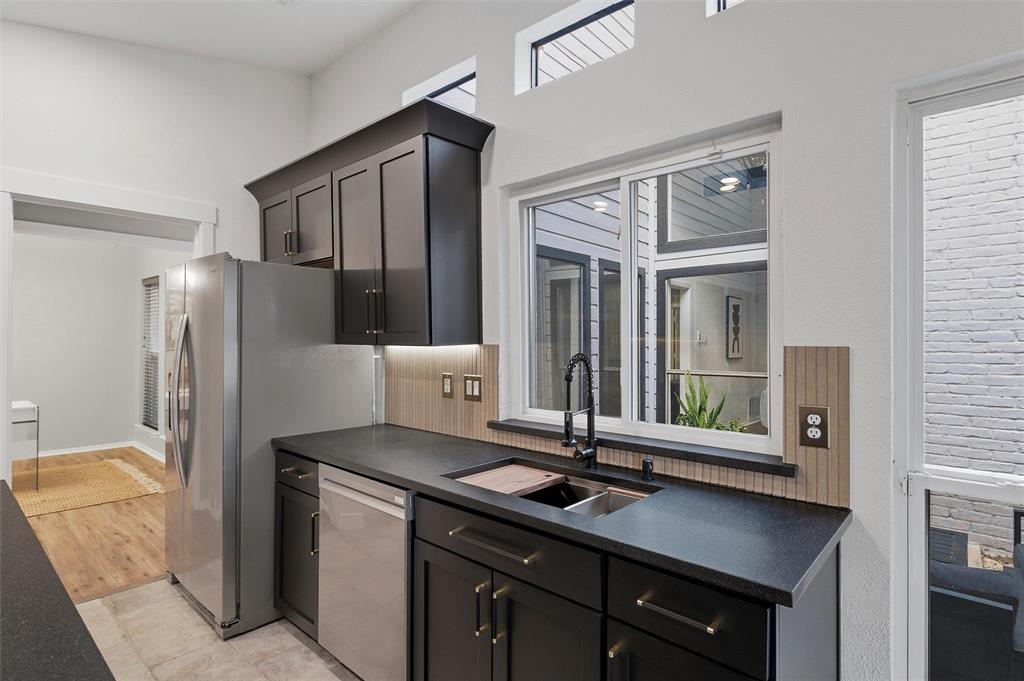 6029 Spring Flower Trail Dallas, TX 75248 - Photo 10 of 37 a kitchen with stainless steel appliances a sink stove and refrigerator
