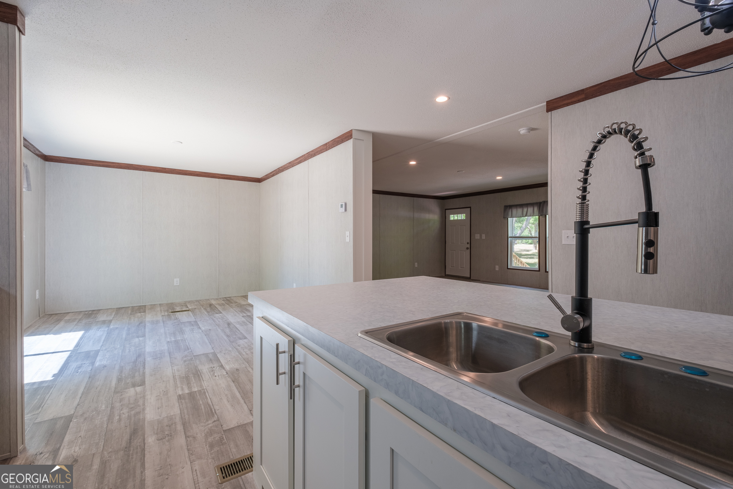 2959 Lake Lannell Road Odum, GA 31555 - Photo 11 of 30 a kitchen with a sink and dishwasher with wooden floor
