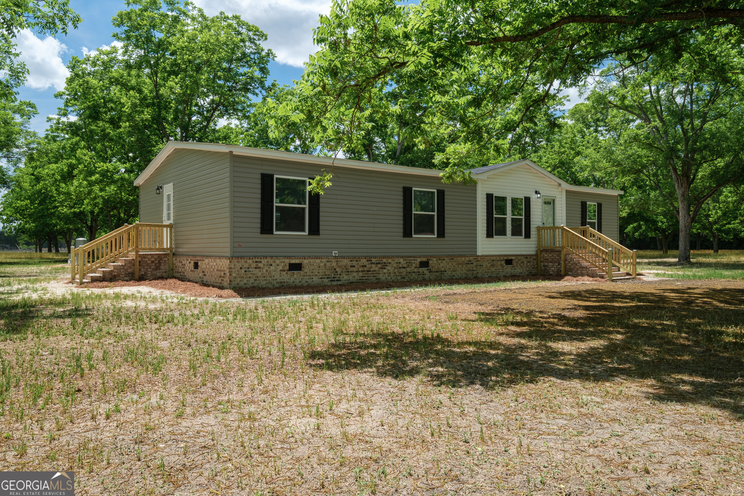 2959 Lake Lannell Road Odum, GA 31555 - Photo 3 of 30 a backyard of a house with large trees and brick walls