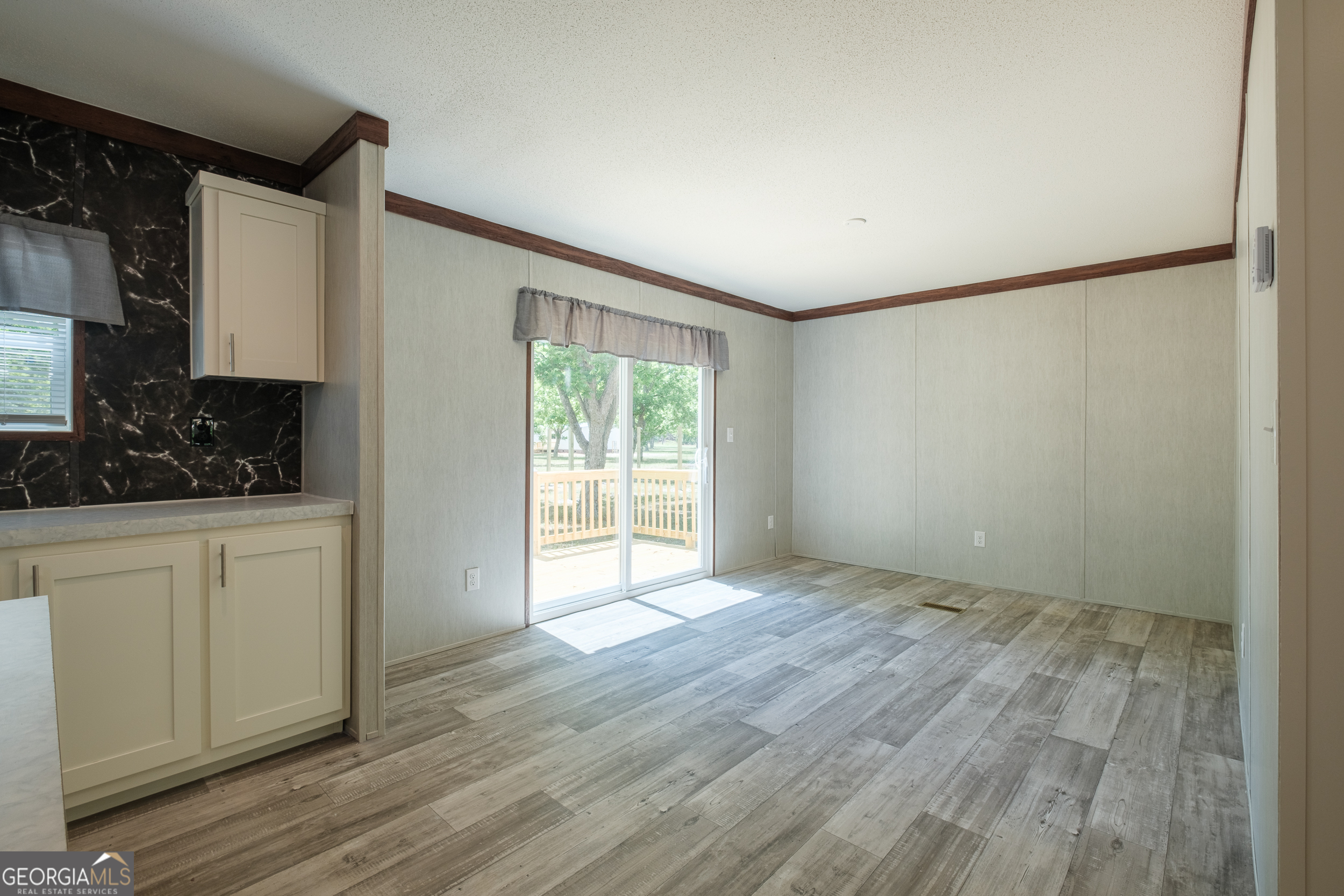 2959 Lake Lannell Road Odum, GA 31555 - Photo 9 of 30 a view of an empty room with wooden floor and a window
