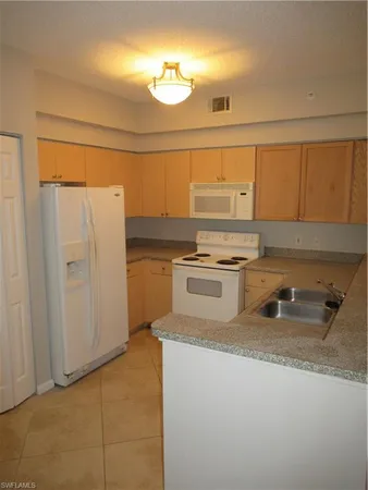 a kitchen with stainless steel appliances a sink and a refrigerator