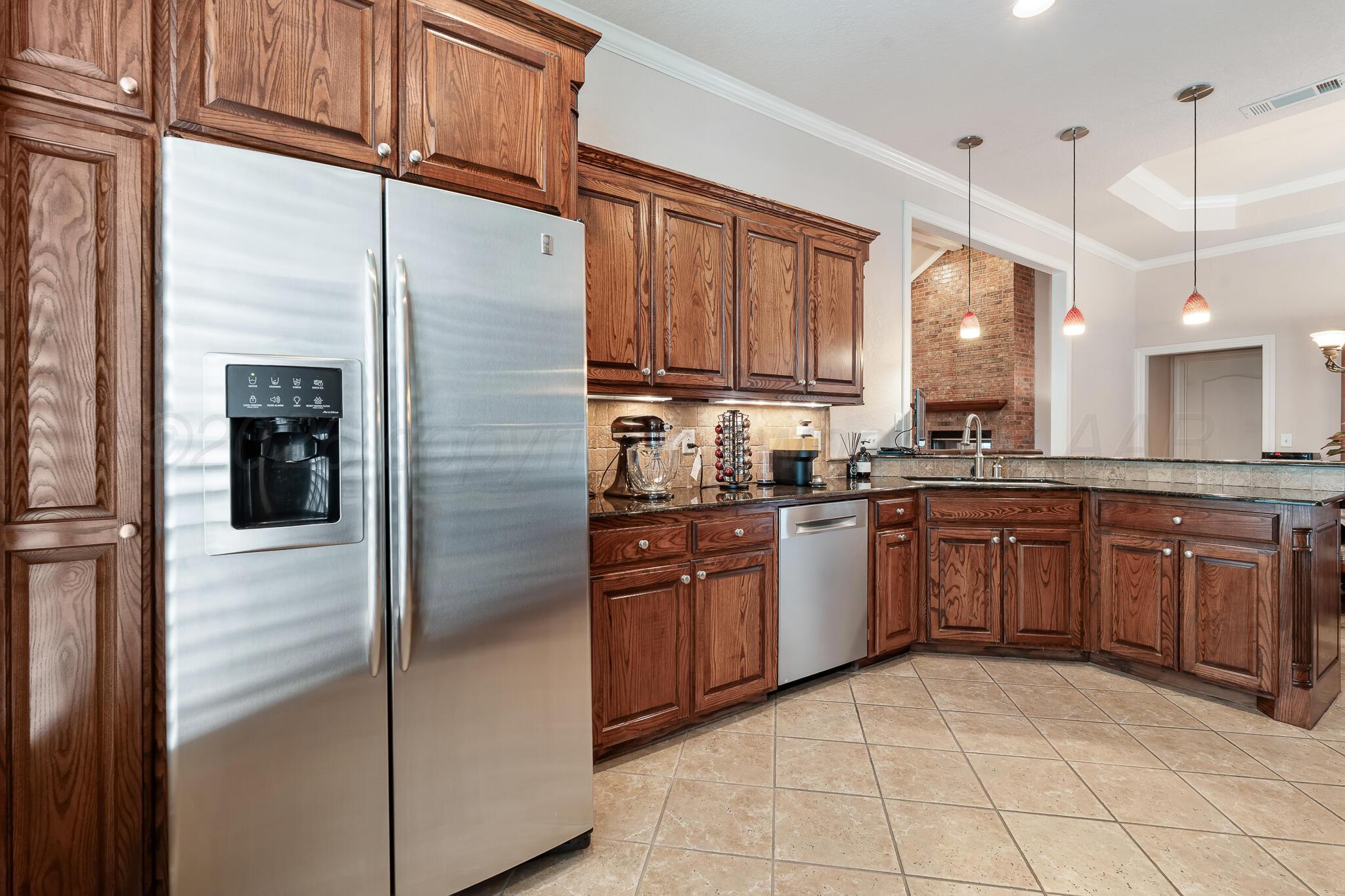 5008 Wesley Road Amarillo, TX 79119 - Photo 7 of 47 a kitchen with stainless steel appliances granite countertop a refrigerator a sink and dishwasher