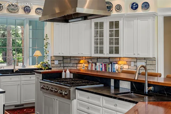 a kitchen with granite countertop a stove a sink and a cabinets