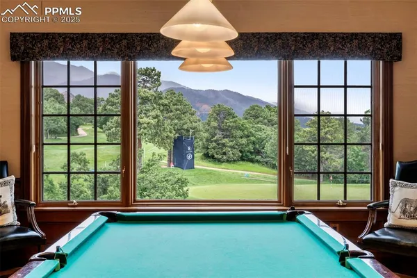 a room with pool table and windows