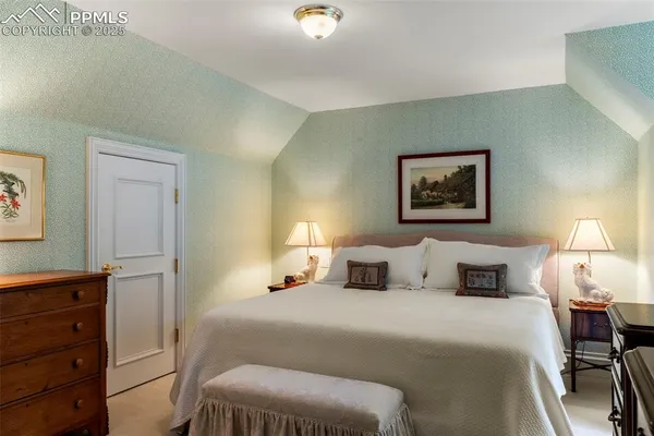 a bedroom with a bed and a lamp on dresser