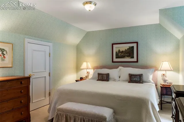a bedroom with a bed and a lamp on dresser