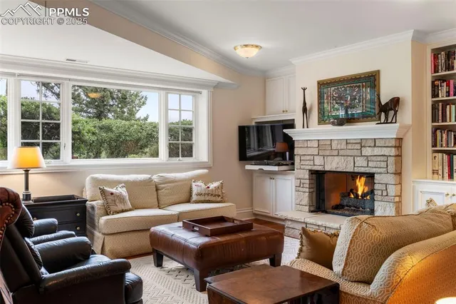 a living room with furniture a fireplace and a large window
