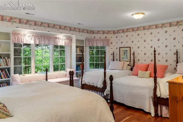 a bedroom with bed and large windows