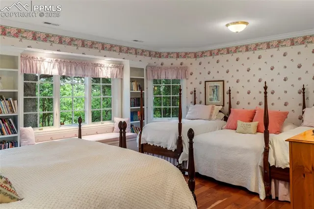 a bedroom with bed and large windows