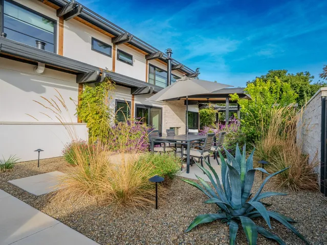 a patio with a table and chairs under an umbrella