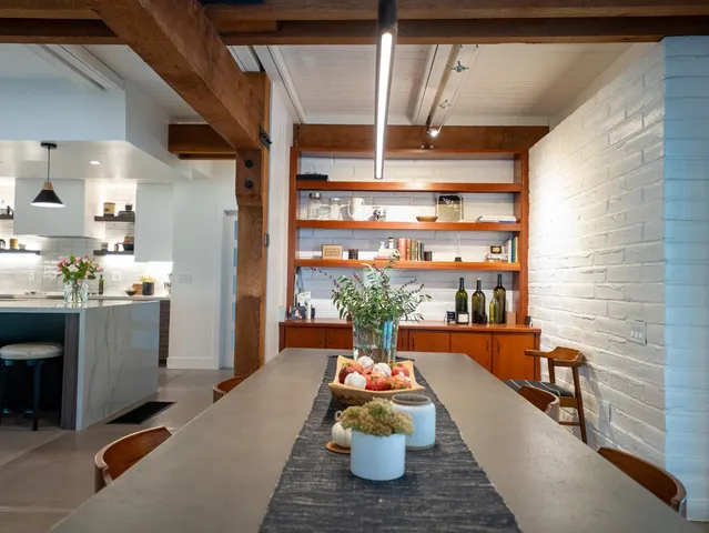 a large white kitchen with wide window and refrigerator