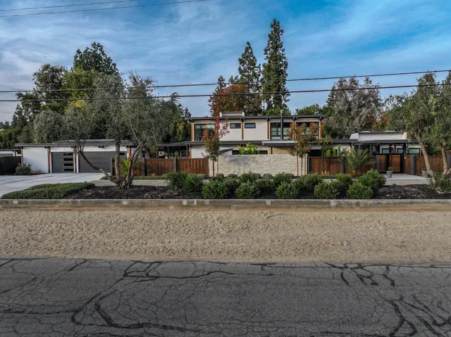 a front view of a house with a yard and trees