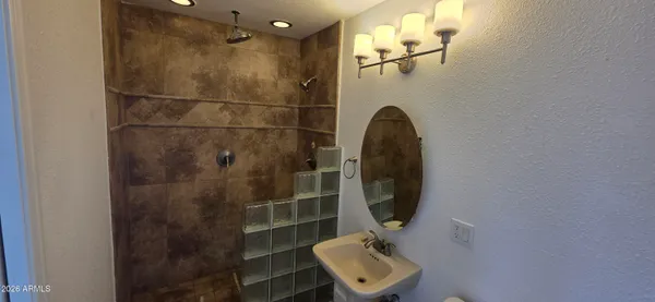 an empty room with a chandelier fan and windows