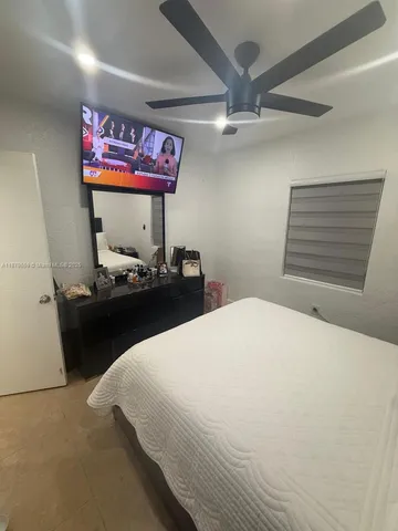 a bedroom with bed and paintings on the wall