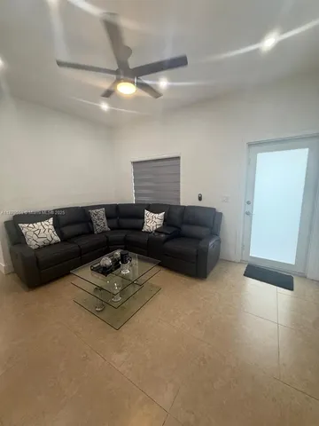 a living room with furniture and a ceiling fan