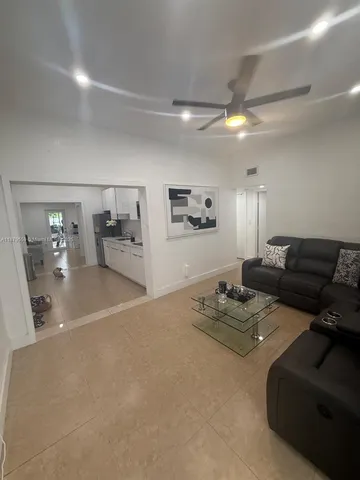 a living room with furniture and view of kitchen