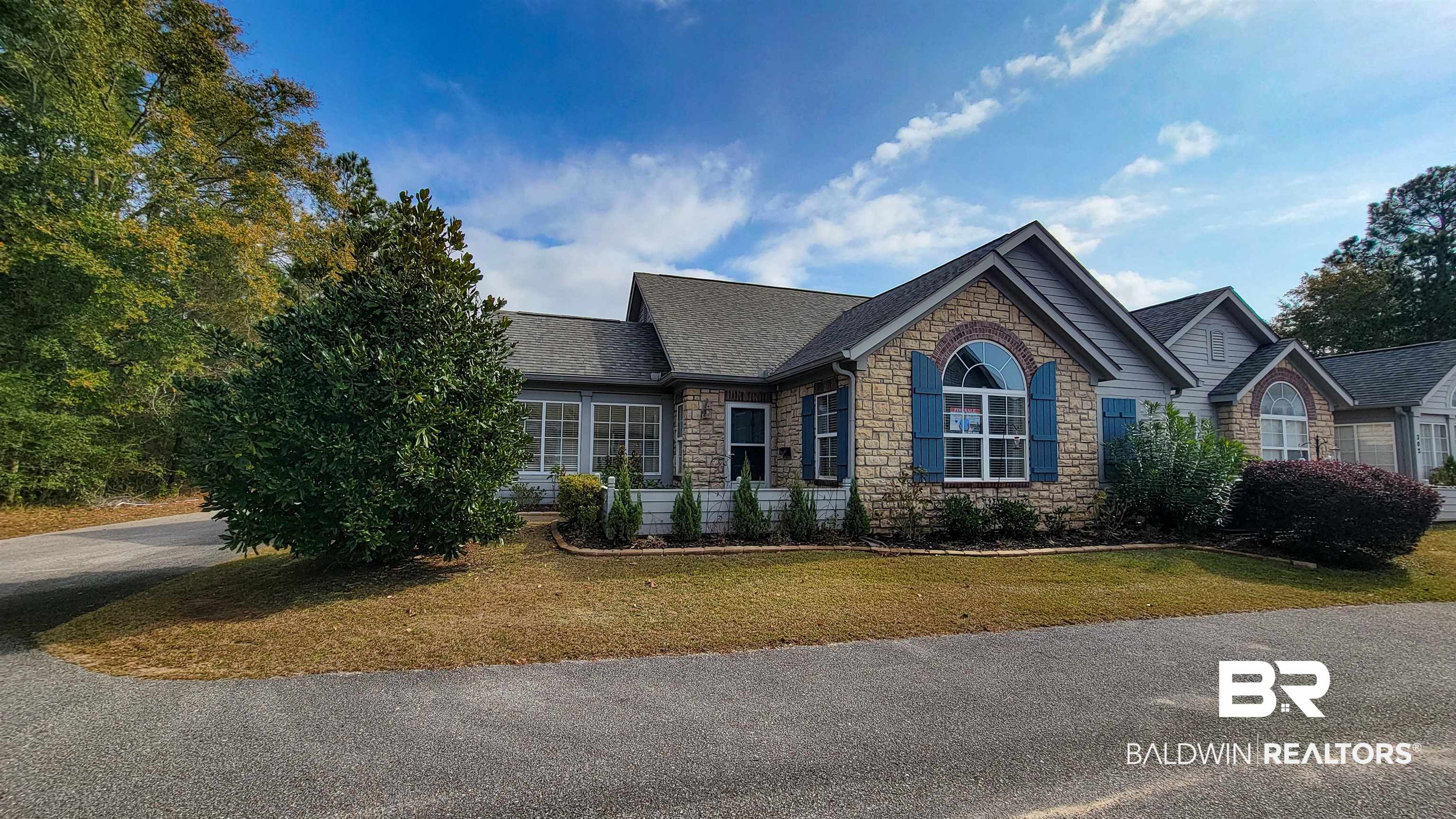 303 Wyld Palms Drive, Unit 303 Foley, AL 36535 - Photo 1 of 36 Ranch-style house with stone siding, roof with shingles, and a front lawn