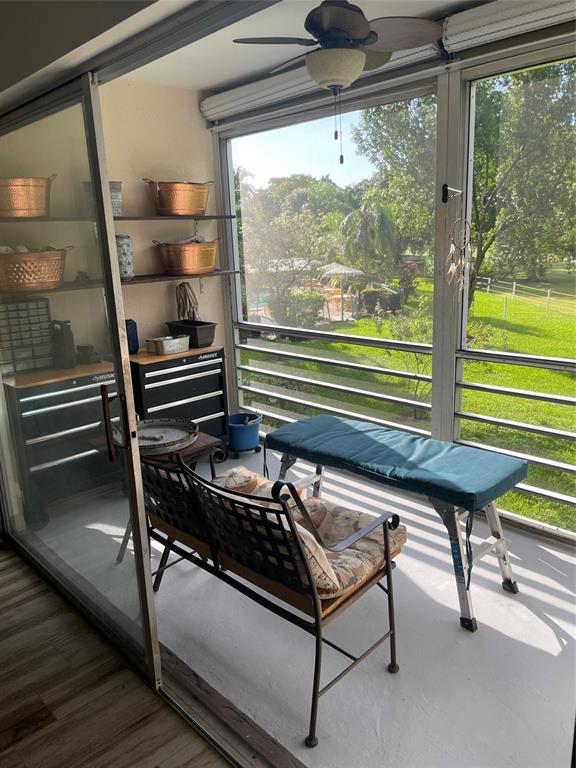 8838 West McNab Road, Unit 201 Tamarac, FL 33321 - Photo 17 of 20 a sitting area with wooden floor and outdoor seating