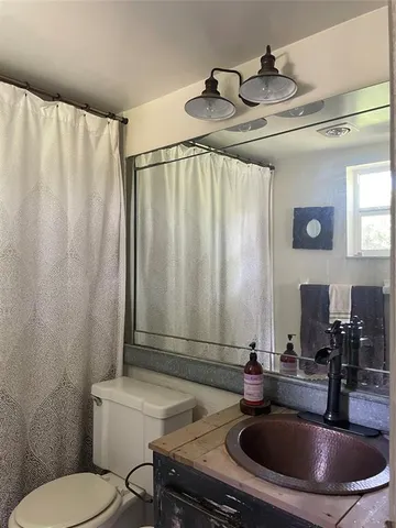 a bathroom with a sink a toilet and a mirror