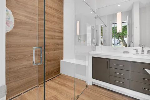 a bathroom with a granite countertop sink and a mirror with toilet