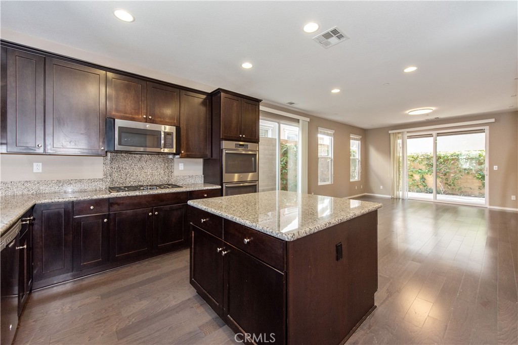 148 Compass Irvine, CA 92618 - Photo 4 of 15 a kitchen with kitchen island granite countertop a sink counter top space and stainless steel appliances
