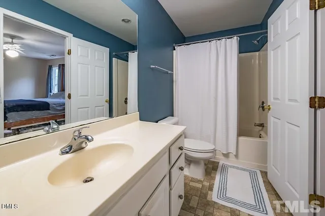 a bathroom with a sink a toilet and shower curtain
