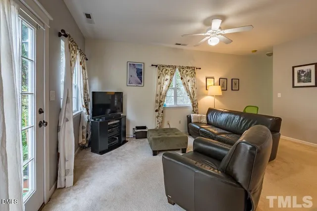 a living room with furniture a ceiling fan and a window