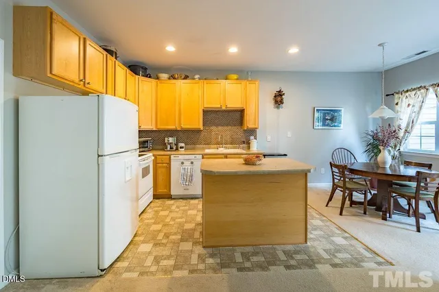 a kitchen with cabinets and a refrigerator