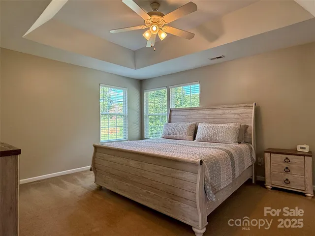 a bed sitting in a bedroom next to a window
