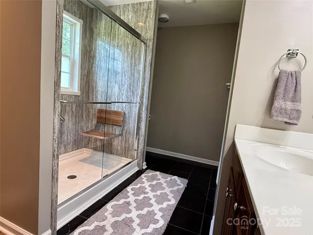 a bathroom with a tub shower vanity and a sink