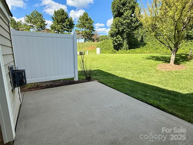 a view of a yard with wooden fence