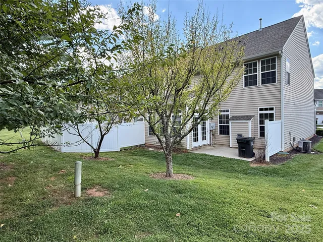a white house that has a tree in front of it