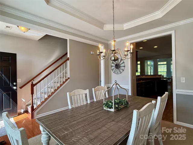 a view of a dining room with furniture a chandelier and wooden floor