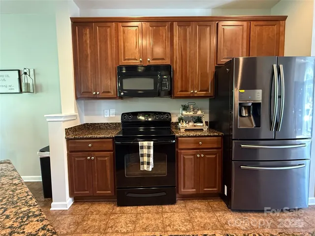 a kitchen with stainless steel appliances granite countertop a refrigerator stove and microwave