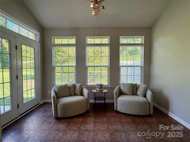 a living room with furniture and a floor to ceiling window