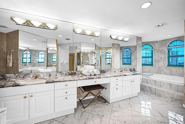 a large bathroom with a glass shower door and a mirror