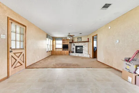 a big room with chandelier fan and windows