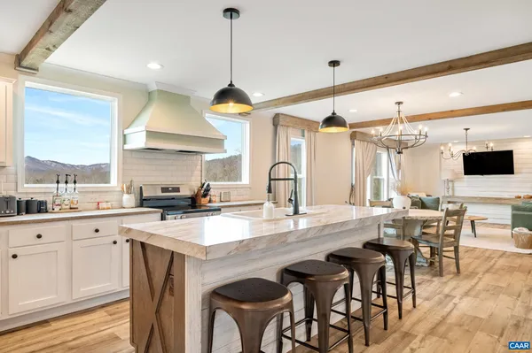 a kitchen with stainless steel appliances granite countertop a sink a stove and chairs