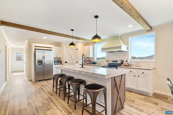 a kitchen with stainless steel appliances a stove and white cabinets