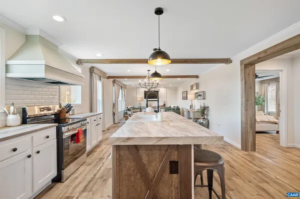 a view of a dining room with furniture a chandelier and wooden floor