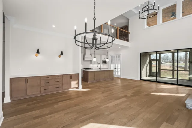 a view of an empty room with wooden floor fireplace and a window